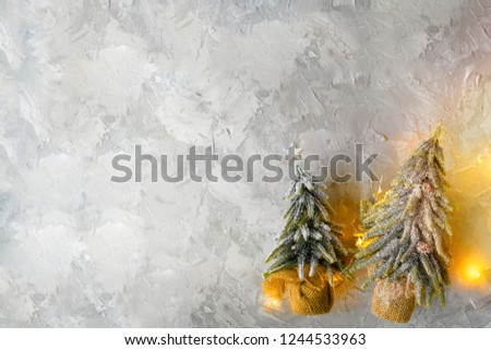 Christmas background with Christmas tree. Two Miniature Christmas tree toys decorated with lights on background.Top view, Flat lay. Copy space