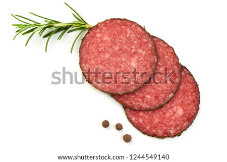 Salami sliced. Raw smoked sausage slices with herbs and spices, isolated on a white background. Top view Royalty-Free Stock Photo #1244549140