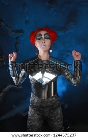 Pretty RedHaired Futuristic Girl With FaceArt Make-Up Wearing Spandex Catsuit and Steel Corset