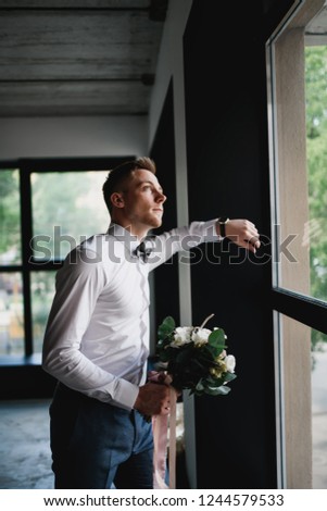 Stylish groom posing in a dark photo Studio. Morning newlyweds.