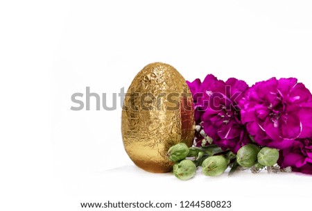 Golden egg and blossom fuchsia flowers on white background.