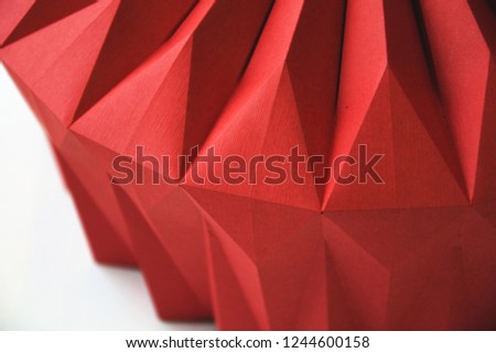 Macro image of paper folded in geometric shapes, three-dimensional effect, abstract background. Out of focus.