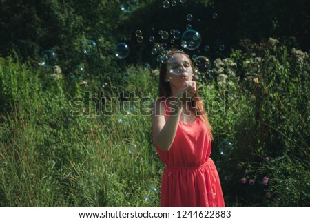 Girl blowing bubbles in the woods
