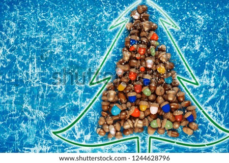 merry christmas and happy new year CARD background handmade handicraft garland of colored acorns, decorative toys and a wooden christmas-tree