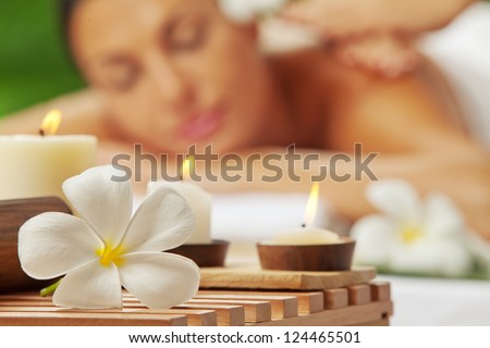 portrait of young beautiful woman in spa environment. blurred face, focused on flower. Royalty-Free Stock Photo #124465501