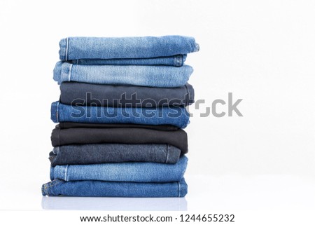 Jeans trousers stack on white background Royalty-Free Stock Photo #1244655232