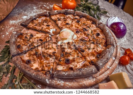 Pizza on wooden background with tomatoes, mushrooms,  basil and mozzarella cheese, close up top view