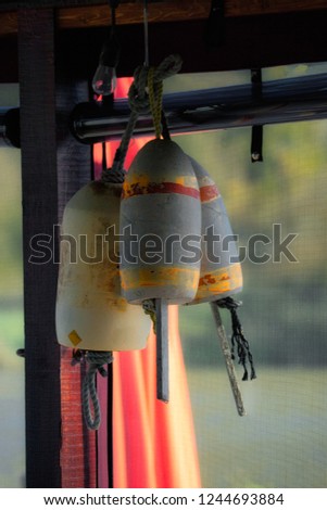 Nautical fishing floats hanging in a sunny bar window. Royalty-Free Stock Photo #1244693884