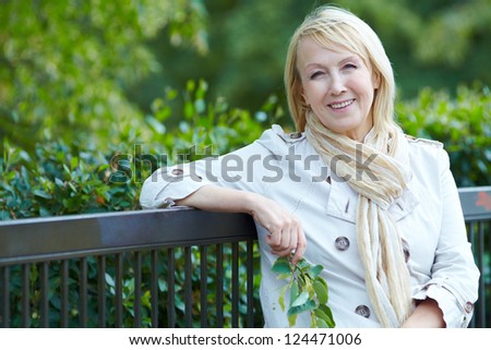 Happy  senior woman  sitting on a park bench
