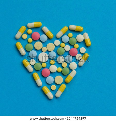 medicinal tablets are decomposed in the form of a heart on a blue background