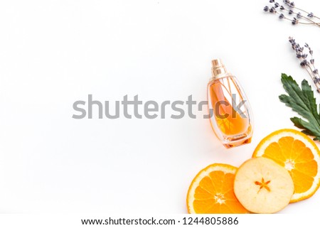 Sweet perfume with fruit fragrance. Bottle  of perfume near apple, orange, lavender on white background top view space for text border Royalty-Free Stock Photo #1244805886