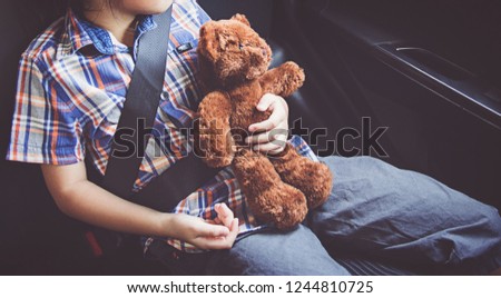 happy little girl wearing seatbelts in car Royalty-Free Stock Photo #1244810725