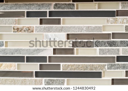 Black, gray, beige, and silver tile backsplash made of glass and stone