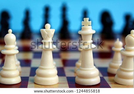 Chess pieces are placed on a checkered board for starting a game