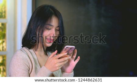 Young Asian Teenage girl using a mobile phone to buy products from an online store with credit card, online surfing and chatting with friends on the social network