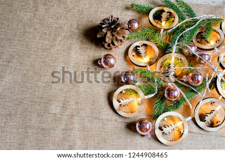 TTop view decorate ornament for christmas background with girland light and small christmas ball  green leaf of pine tree and brown fruit with put on tissue , 