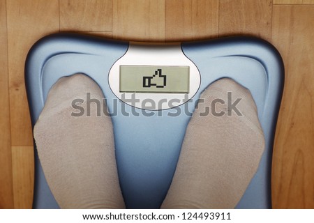 A scale with two feet of the person standing on it on a wooden floor. The scale says: "LIKE". Royalty-Free Stock Photo #124493911
