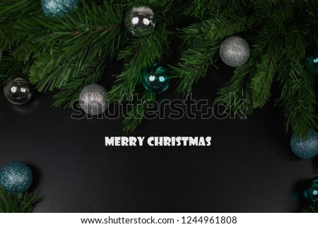 Christmas wooden black background with fir branches, blue and silver balls