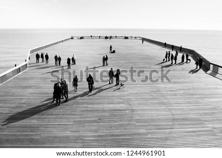 Shadows of people walking on Hastings Pier