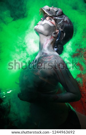 Hot Scary Death BodyArt Woman With 3d sculls Posing In The Green Smoke