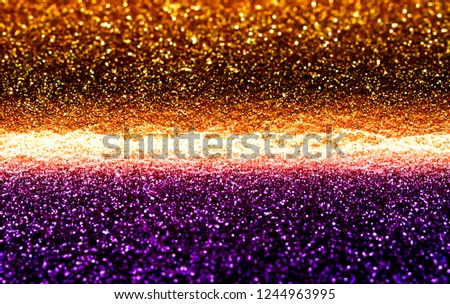 Bright purple and dark orange, two tone defocused glitter texture background.