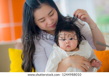 young happy and cute Asian Korean woman playing and holding sweet adorable baby girl sitting at holidays resort enjoying summer vacation trip in mother and little daughter love concept 