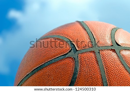 old basketball against a blue, cloudy sky