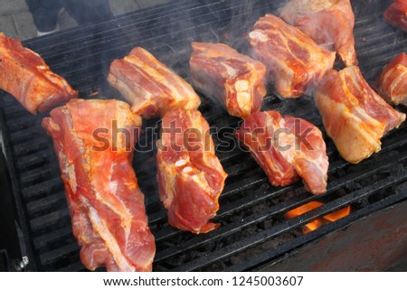 Pork breast on barbeque. Ribs roasted on a bbq. Grilled meat on a sunlight, background wallpaper. Restaurant and food concept. Menu cover photo. Barbecued and marinated sticky spare ribs, copy space.