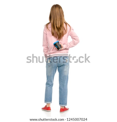 Beautiful woman in jeans with cup of coffee in hand walking goes on a white background isolation back view