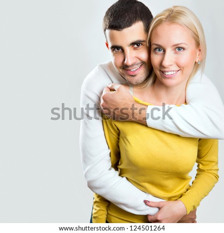 Happy smiling couple in love. Over gray background