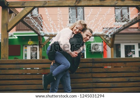 a young and lovely couple standing near a building in a spring city