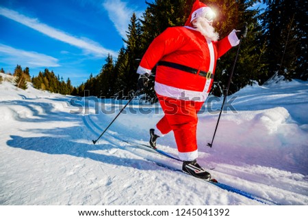 Fat Santa Claus with Christmas suits with classic  nordic ski in snowy winter mountain ski resort landscape in sunny day, New Year's or xmas is coming.