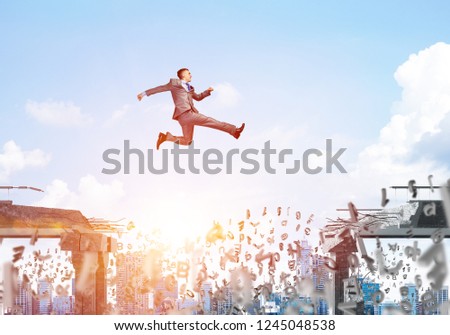 Businessman jumping over gap with flying letters in concrete bridge as symbol of overcoming challenges. Cityscape with sunlight on background. 3D rendering.