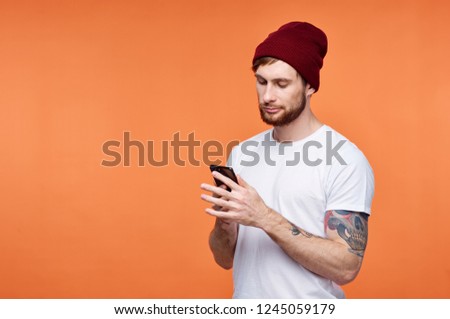 Cute man in a cap looks into the phone                               