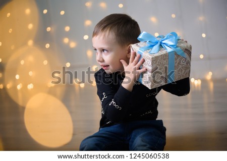 A little boy in a beautiful New Year's photo studio. New year and gifts. Magic.