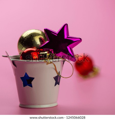 Christmas toys and a candlestick on a pink background. Christmas composition, winter season. For your design.