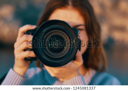 A camera with a big lens and a happy photographer in nature                 