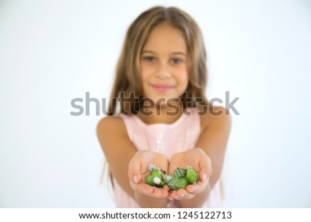 Little girl in a pink dress holds in her hands a cocoons with future butterflies