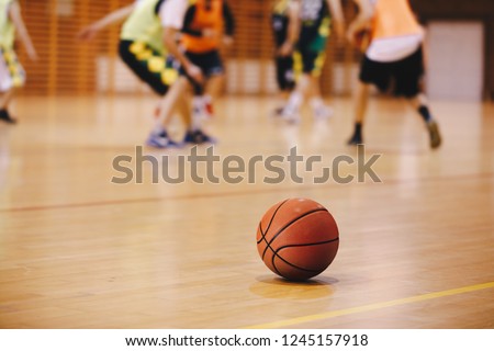 Basketball Training Game Background. Basketball on Wooden Court Floor Close Up with Blurred Players Playing Basketball Game in the Background
 Royalty-Free Stock Photo #1245157918