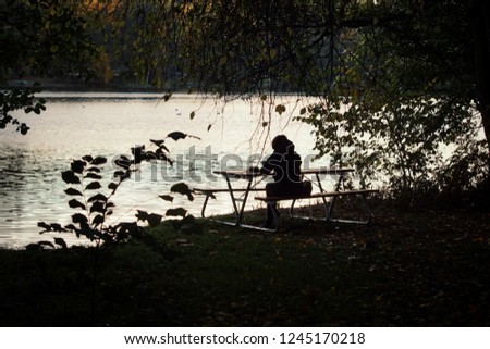one person sitting at a lake 