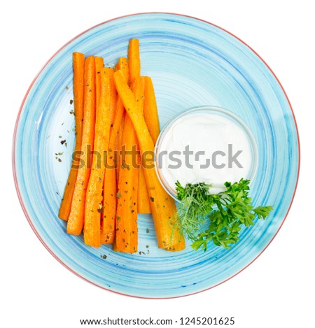 Picture of  tasty fried carrot sticks and served with sour cream at plate. Isolated over white background