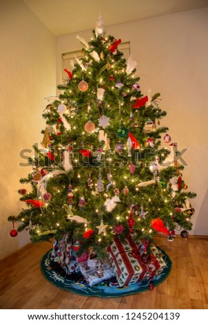 Close up of a decorated christmas tree with multicolorod ornaments and white lights