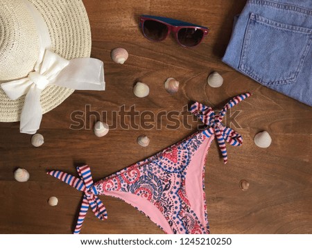Summer Beach Outfit. Accessories stylish girl set. Vacation concept on wooden table background. Top view, flat lay.