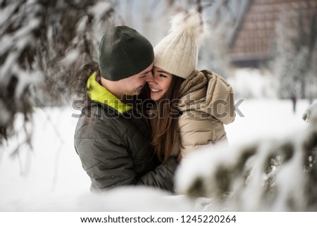 Young couple embracing with snow in background