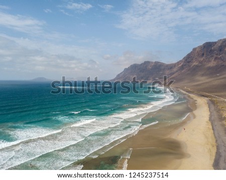 Aerial view of Famara beach, Lanzarote, Canary Islands, Spain. Kite surfer. Ocean waves