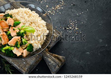 Rice with chicken fillet and vegetables. Top view. On a black background. Free copy space.