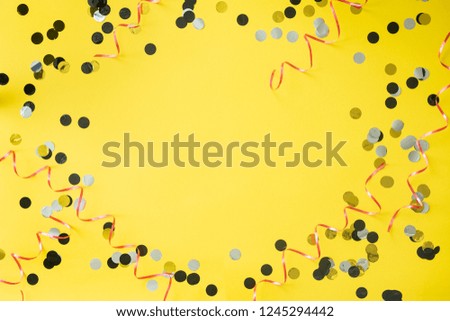 Birthday party background. Yellow table with confetti and ribbon. Place for text.