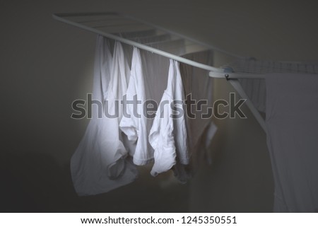 white clothes on drying rack, banner with dark background