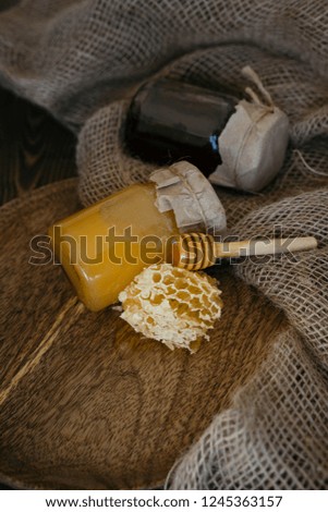honey in a jar and honeycomb on a wooden background