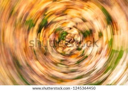 Concept vertigo slow shutter speed swirling golden autumn or fall leaves